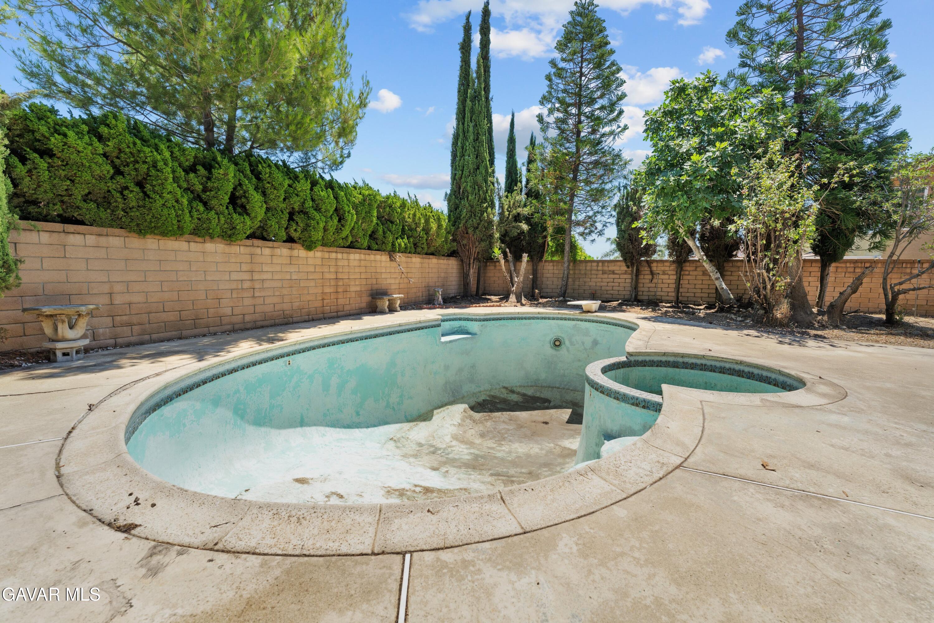 6113 Sard Street Rancho Cucamonga, CA 91701 - Photo 24 of 26 a view of a swimming pool with a yard and trees in the background