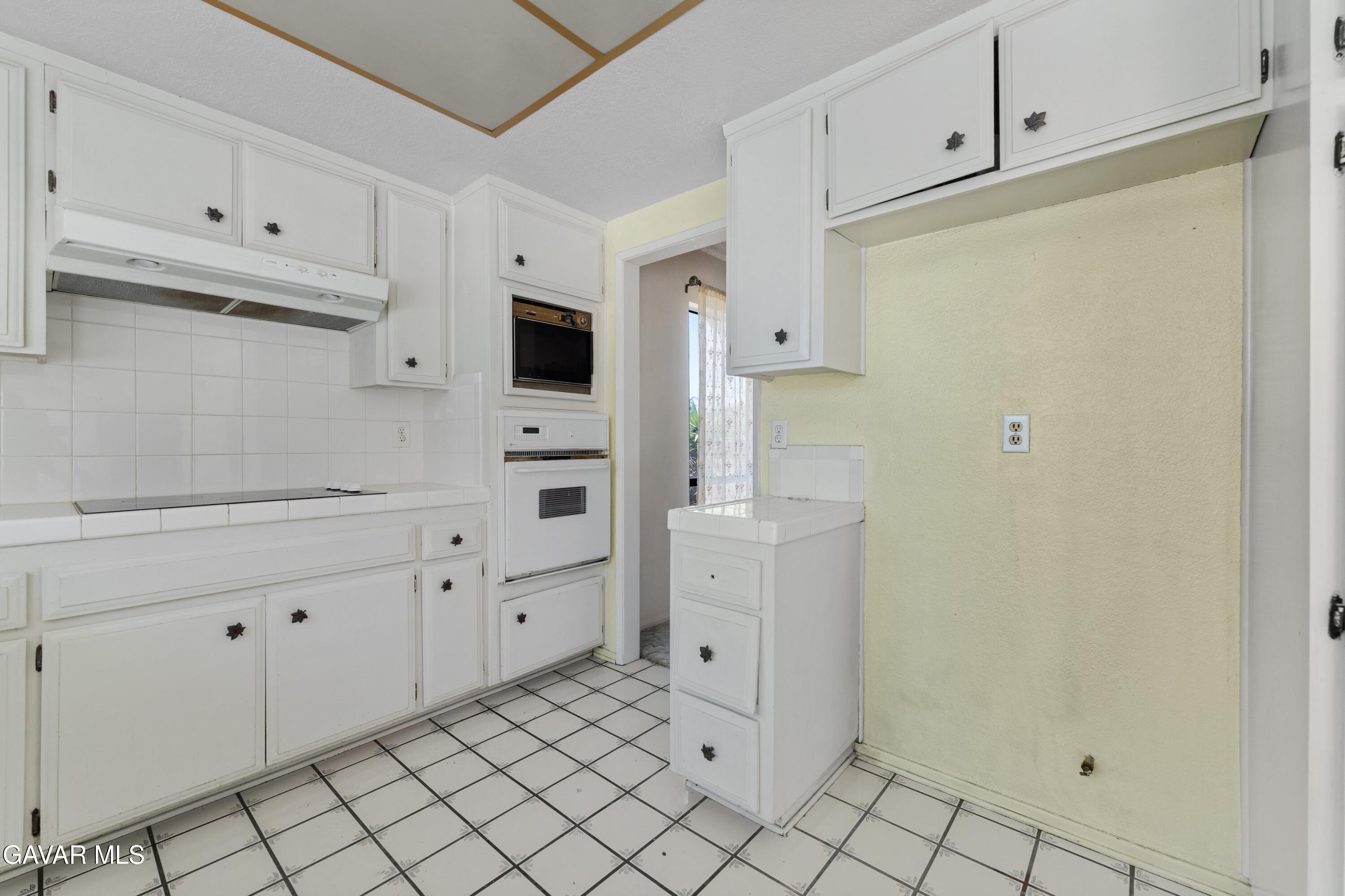 6113 Sard Street Rancho Cucamonga, CA 91701 - Photo 7 of 26 a kitchen with white cabinets and white appliances