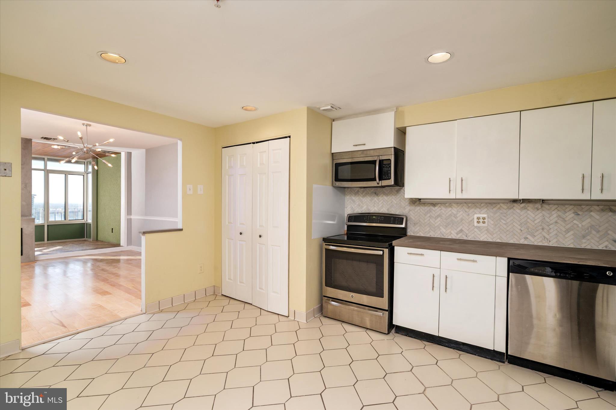 28 Allegheny Avenue, Unit 2710 Towson, MD 21204 - Photo 10 of 40 a kitchen with white cabinets a sink and stainless steel appliances