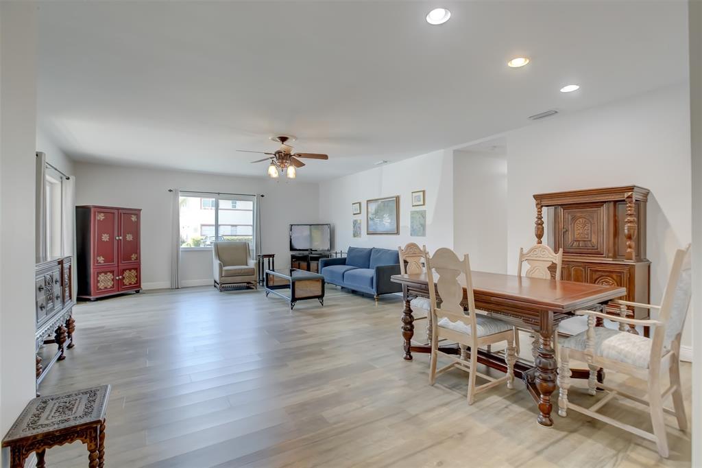 1450 North Riverside Drive, Unit 101 Pompano Beach, FL 33062 - Photo 12 of 52 a living room with furniture and a dining table with wooden floor