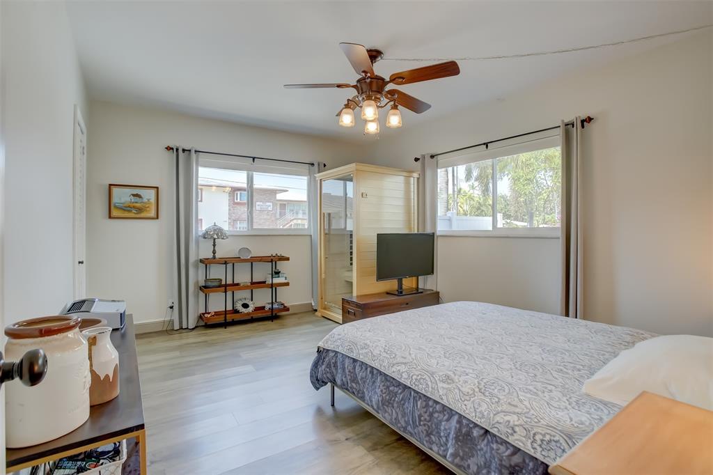 1450 North Riverside Drive, Unit 101 Pompano Beach, FL 33062 - Photo 18 of 52 a bedroom with a bed and a chandelier