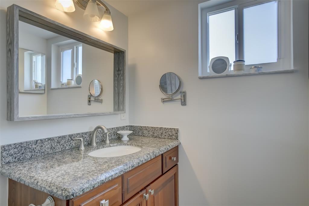 1450 North Riverside Drive, Unit 101 Pompano Beach, FL 33062 - Photo 24 of 52 a bathroom with a granite countertop sink and a mirror