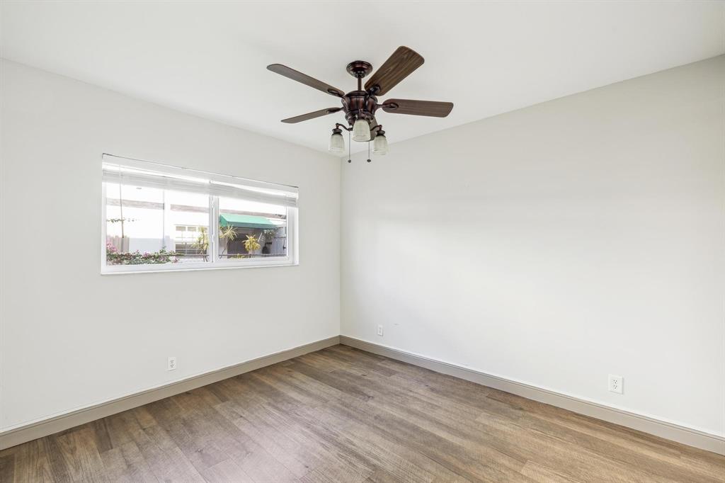 1450 North Riverside Drive, Unit 101 Pompano Beach, FL 33062 - Photo 26 of 52 an empty room with wooden floor a ceiling fan and a window