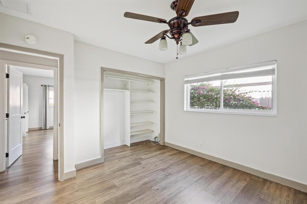 1450 North Riverside Drive, Unit 101 Pompano Beach, FL 33062 - Photo 28 of 52 an empty room with wooden floor chandelier fan and windows