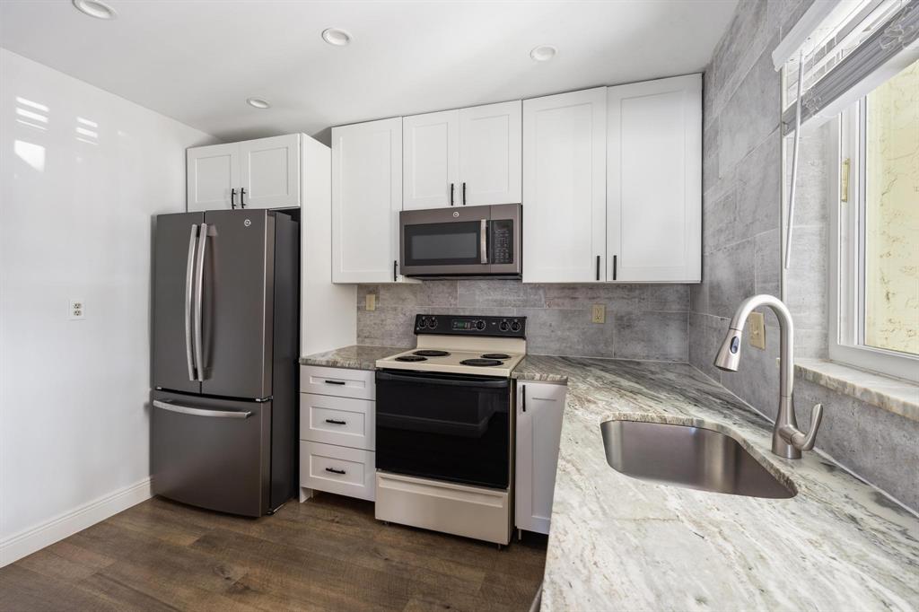 1450 North Riverside Drive, Unit 101 Pompano Beach, FL 33062 - Photo 4 of 52 a kitchen with a refrigerator sink and microwave