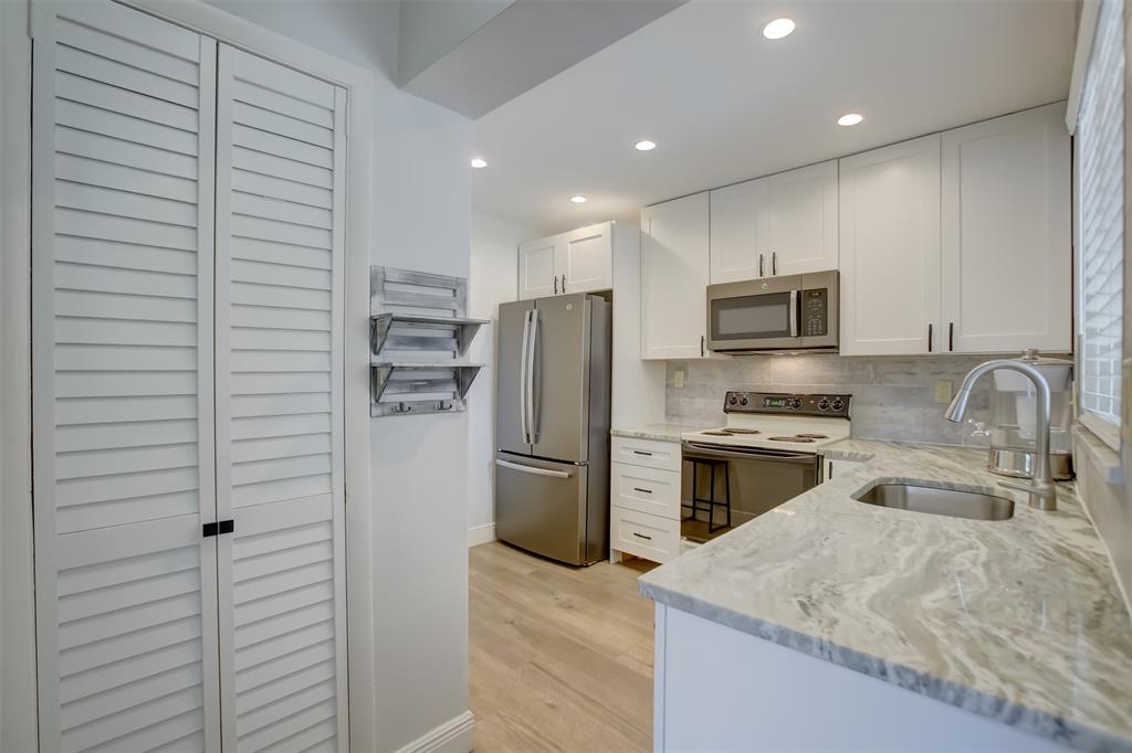 1450 North Riverside Drive, Unit 101 Pompano Beach, FL 33062 - Photo 5 of 52 a kitchen with a refrigerator microwave and sink