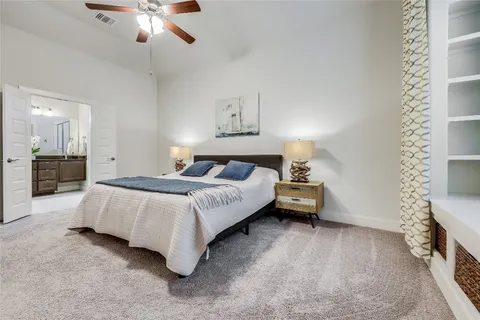 a spacious bedroom with a bed and a chandelier