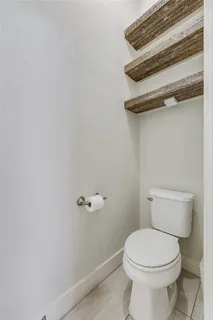 a white toilet sitting next to a shower