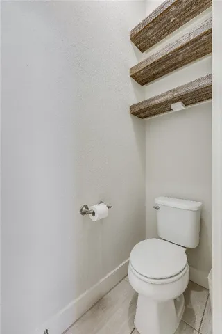a white toilet sitting next to a shower