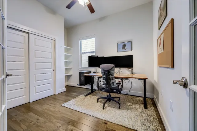 a view of a workspace with furniture and a window