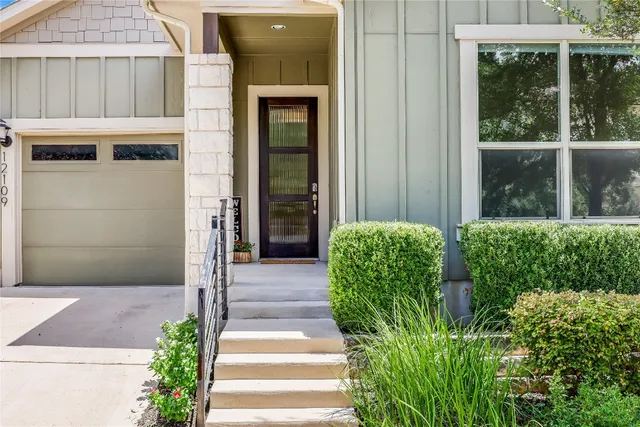 a front view of a house with a yard and plants