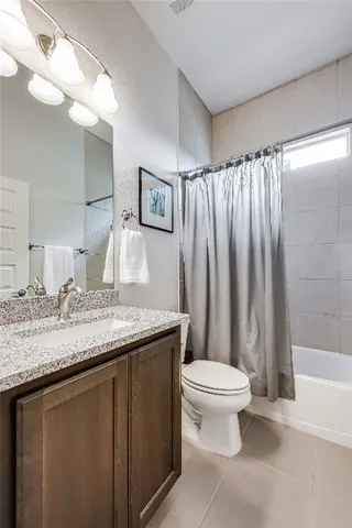 a bathroom with a granite countertop sink a toilet and a mirror