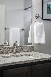 a bathroom with a granite countertop sink and a mirror