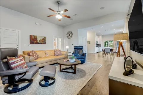 a living room with furniture and a flat screen tv with kitchen view
