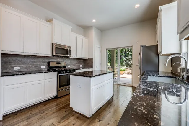a kitchen with sink a stove and cabinets