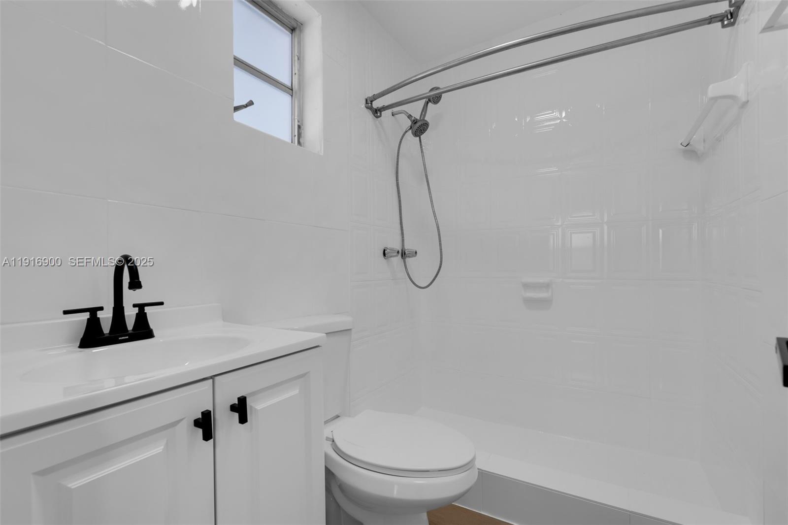 11030 Southwest 42nd Street Miami, FL 33165 - Photo 23 of 34 a bathroom with a shower a toilet and sink