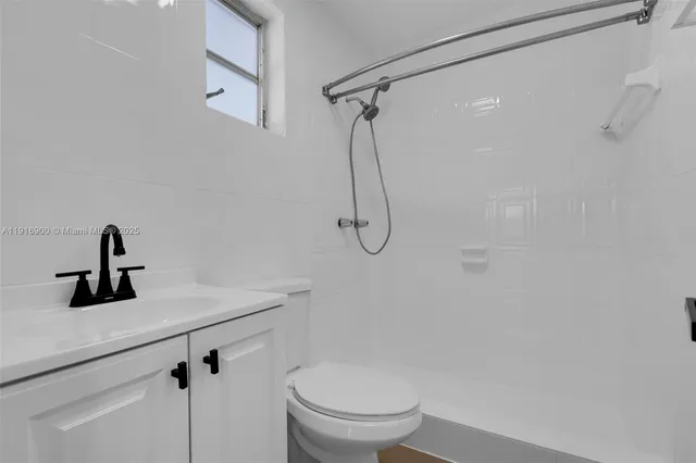 a bathroom with a shower a toilet and sink