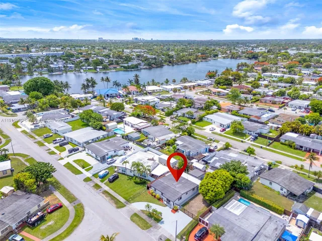 an aerial view of a city with lots of residential buildings ocean and mountain view in back