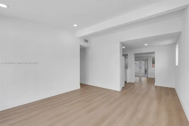 a view of a room with wooden floor and a window