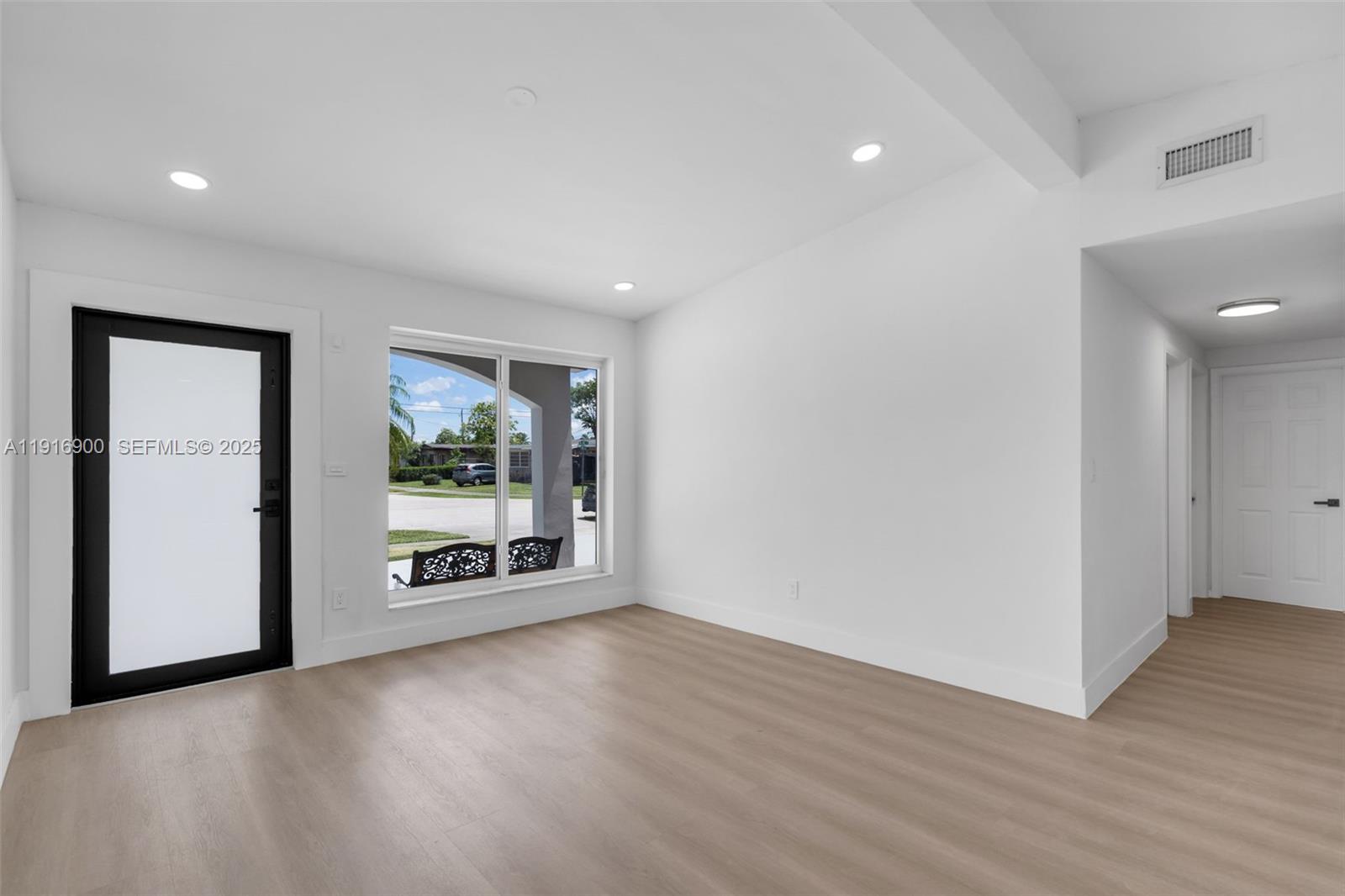 11030 Southwest 42nd Street Miami, FL 33165 - Photo 6 of 34 an empty room with wooden floor and windows