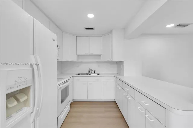 a kitchen with white cabinets and white appliances