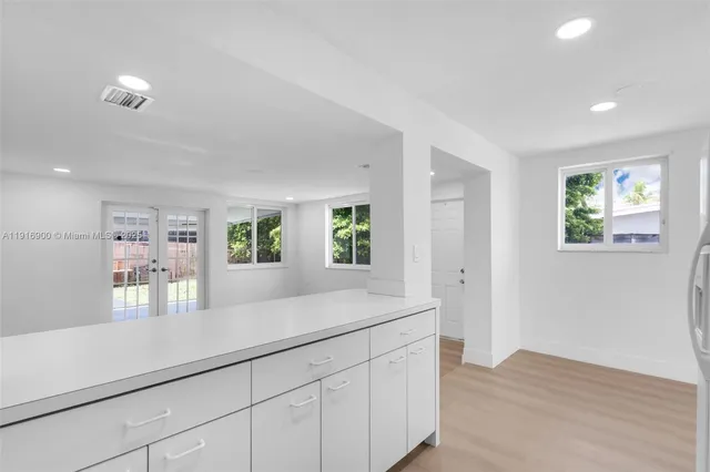 a kitchen with kitchen island a stove a sink and a refrigerator with wooden floors