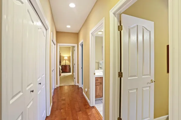 a view of a hallway with wooden floor and closet area
