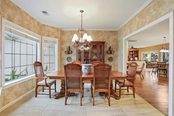 a dining room with furniture a chandelier and window