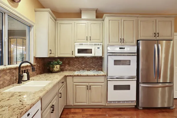 a kitchen with appliances a sink and cabinets
