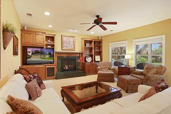 a living room with furniture a flat screen tv and a large window
