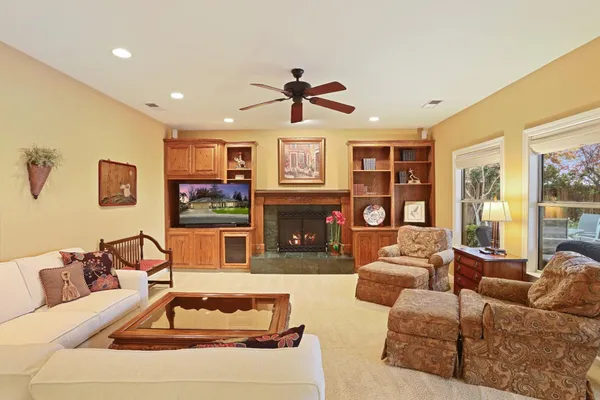 a living room with fireplace furniture and a large window