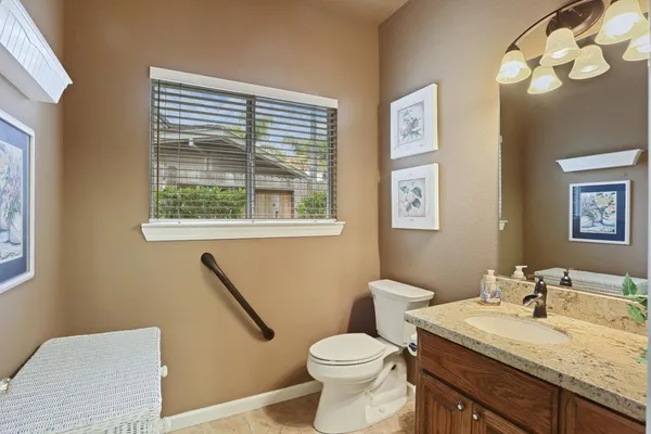 a bathroom with a granite countertop sink mirror vanity and toilet