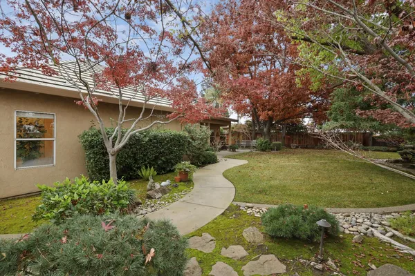 a view of a backyard house with large trees