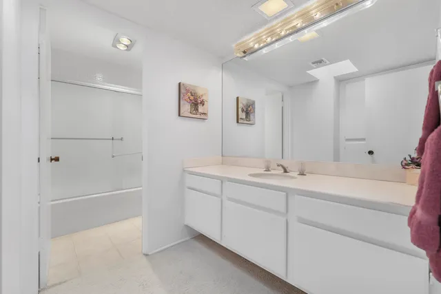 a bathroom with a tub sink and mirror