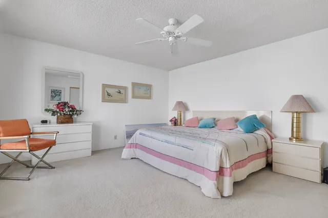 a spacious bedroom with a bed and a chandelier