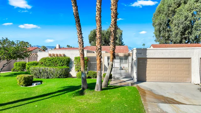 a view of a house with backyard and a tree