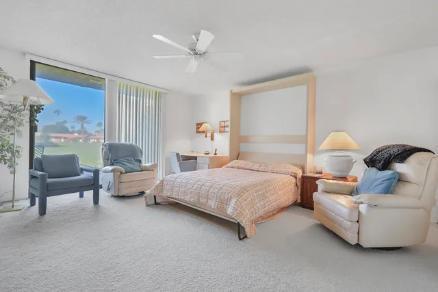 a spacious bedroom with a bed and glass window