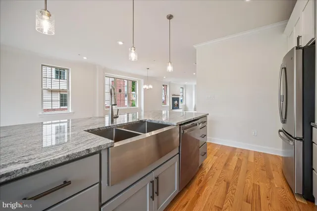 a kitchen with granite countertop a sink and refrigerator