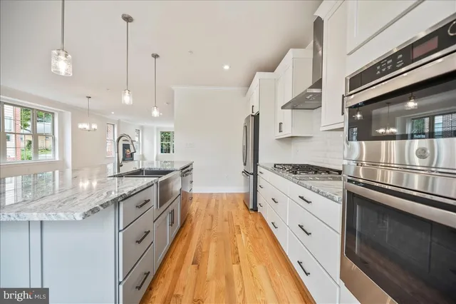 a large kitchen with granite countertop a stove and a sink