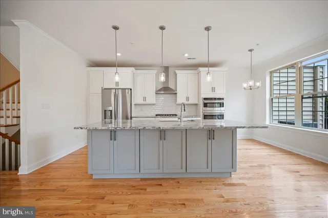 a large kitchen with kitchen island white cabinets and stainless steel appliances