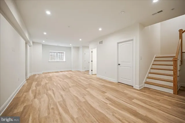 a view of empty room with wooden floor and entryway