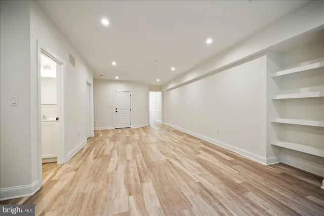 a view of empty room with wooden floor