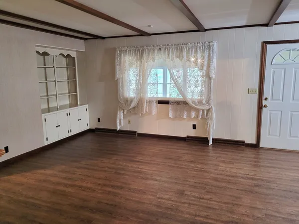 a view of a livingroom with wooden floor and a ceiling fan