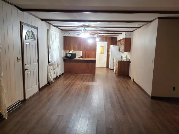 a view of a livingroom with wooden floor and a fireplace