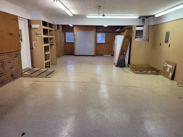 a view of an empty room with a cabinet and mirrors