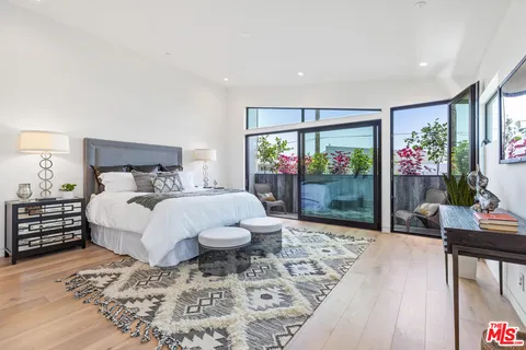 a bed sitting in a spacious bedroom next to a window