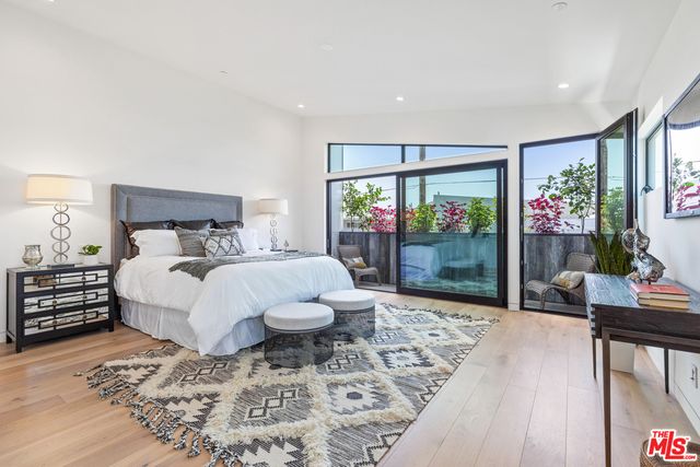 a bed sitting in a spacious bedroom next to a window