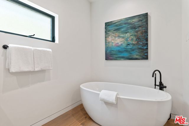 a white bath tub sitting next to a white wall
