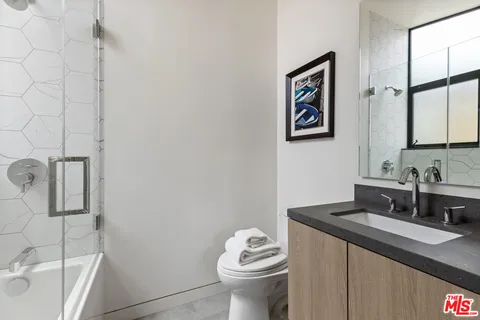a bathroom with a granite countertop sink mirror vanity and toilet