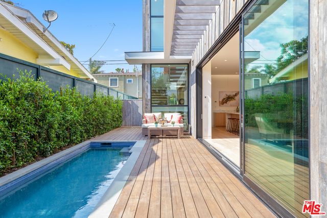 a view of pool with lawn chairs and couches